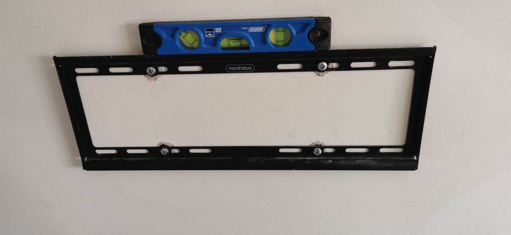 TV wall bracket being checked with a spirit level
